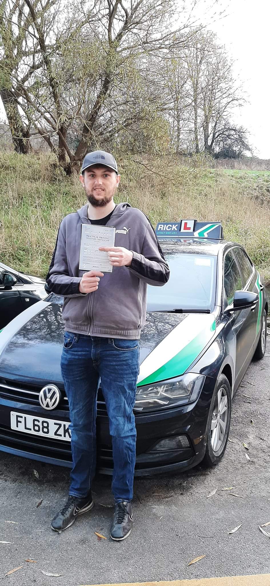 A learner with a driving test pass certificate beside Rick's black and green learner car